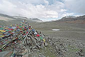 Ladakh - pile of stones on  mountain pass with the characteristc prayer flags